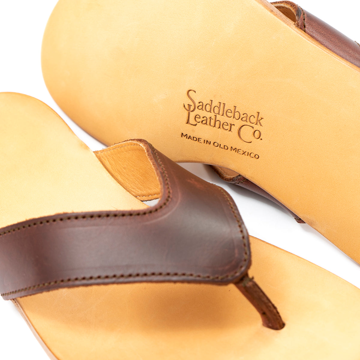 Close-up of Flip Flops in Chestnut leather showing the strap and Made in Old Mexico logo stamp on the sole