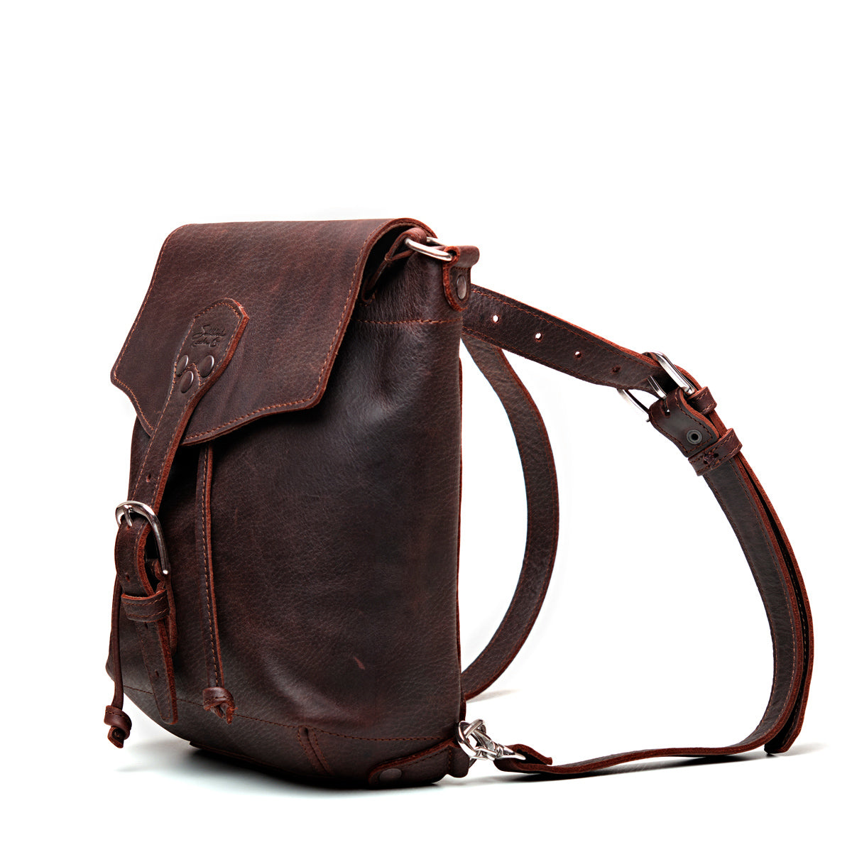 10" Convertible Crossbody in Chestnut, angled view with buckled flap and straps set up as a backpack
