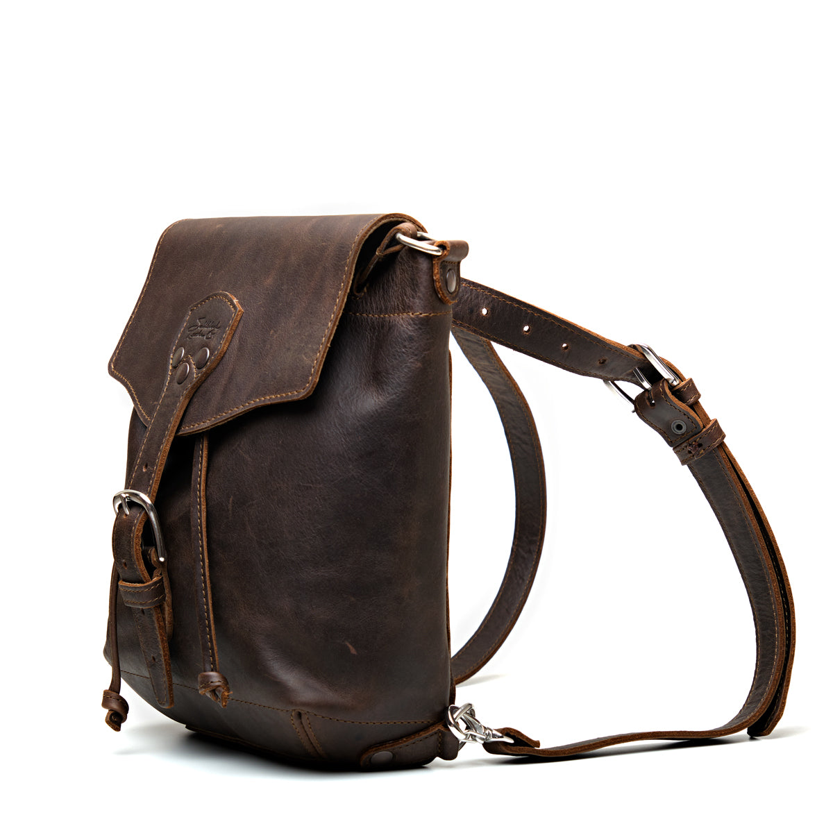 10" Convertible Crossbody in Dark Coffee Brown, angled view with buckled flap and straps set up as a backpack