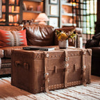Leather Trunk in Tobacco used as a coffee table in a living room, topped with a book and a vase of flowers