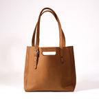 Everyday Leather Tote in Tobacco, back view with shoulder handles, cutout grip and buckled side strap