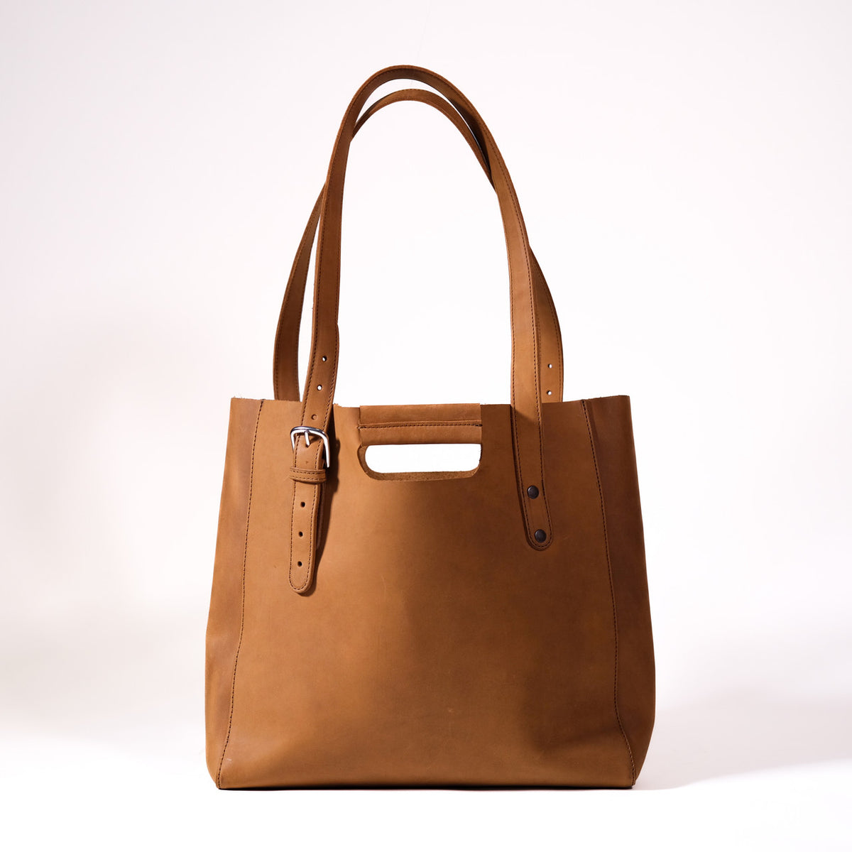 Everyday Leather Tote in Tobacco, back view with shoulder handles, cutout grip and buckled side strap