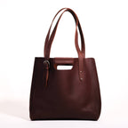 Everyday Leather Tote in Chestnut, back view with shoulder handles, cutout grip and buckled side strap