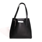 Everyday Leather Tote in Black, back view with shoulder handles, cutout grip and buckled side strap