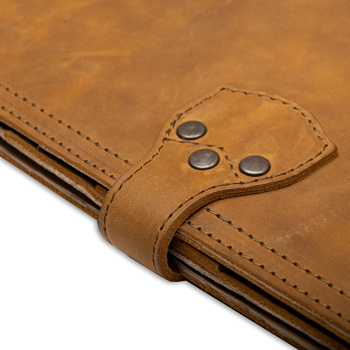 Large Leather Portfolio in Tobacco, close-up of the riveted strap closure and stitched edges