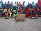 Large Classic Leather Briefcase in Tobacco on a dirt field in front of a seated soccer team and onlookers
