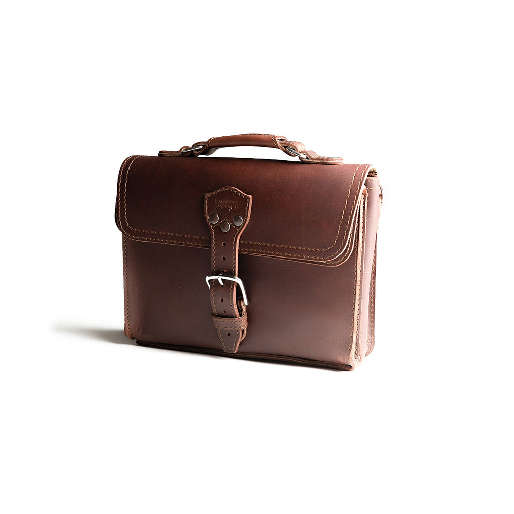 Front Pocket Leather Satchel in Chestnut, angled front view with top handle and buckled front pocket