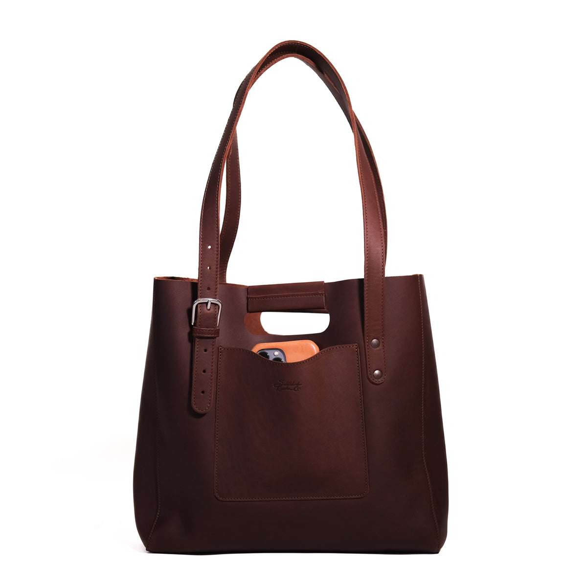 Everyday Leather Tote in Chestnut, front view with shoulder handles, buckled side strap and a phone in the front pocket
