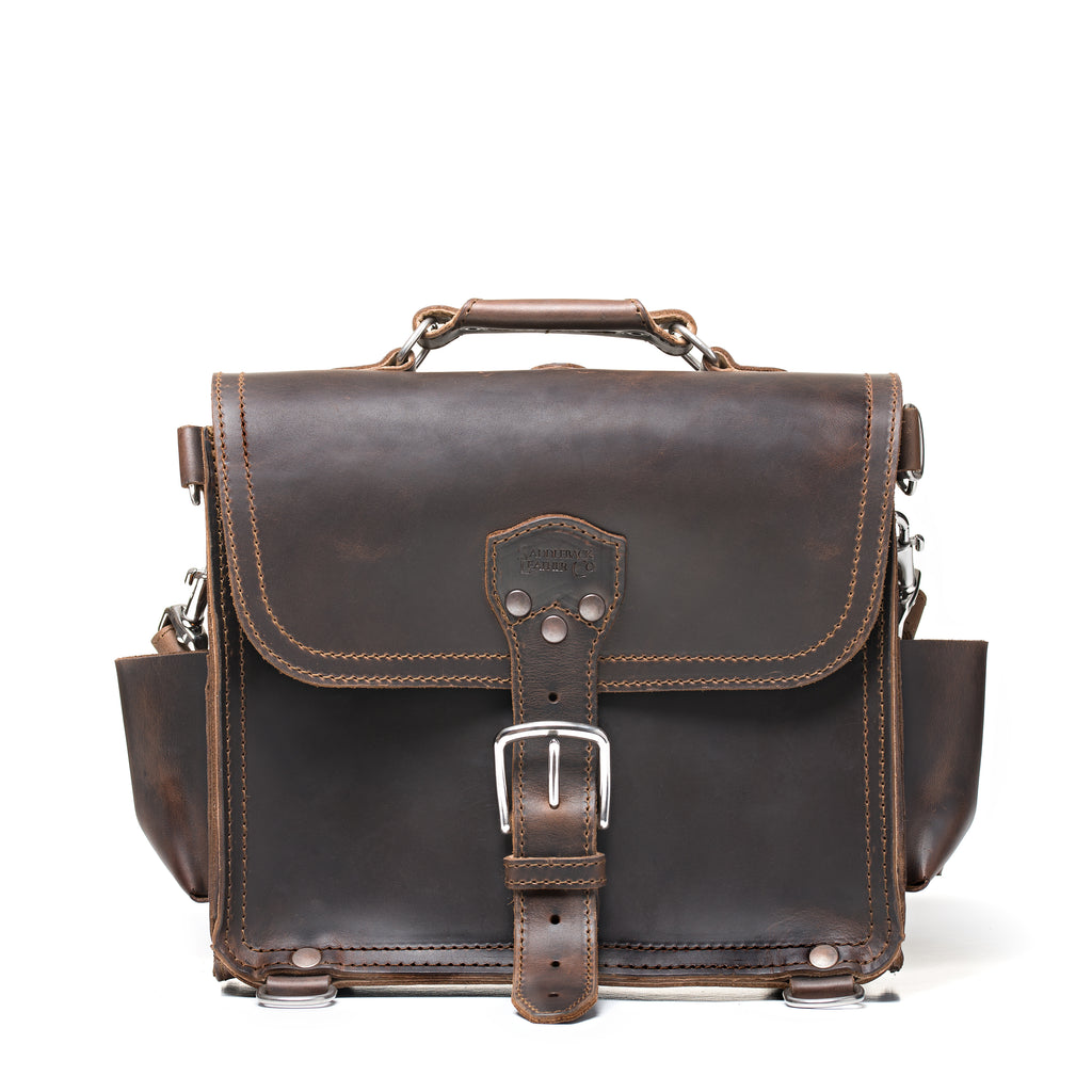 Photographer's Satchel in Dark Coffee Brown, front view with buckled flap, top handle and side pockets