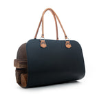 Leather Log Carrier in Black with tan carry handles, holding firewood, side view