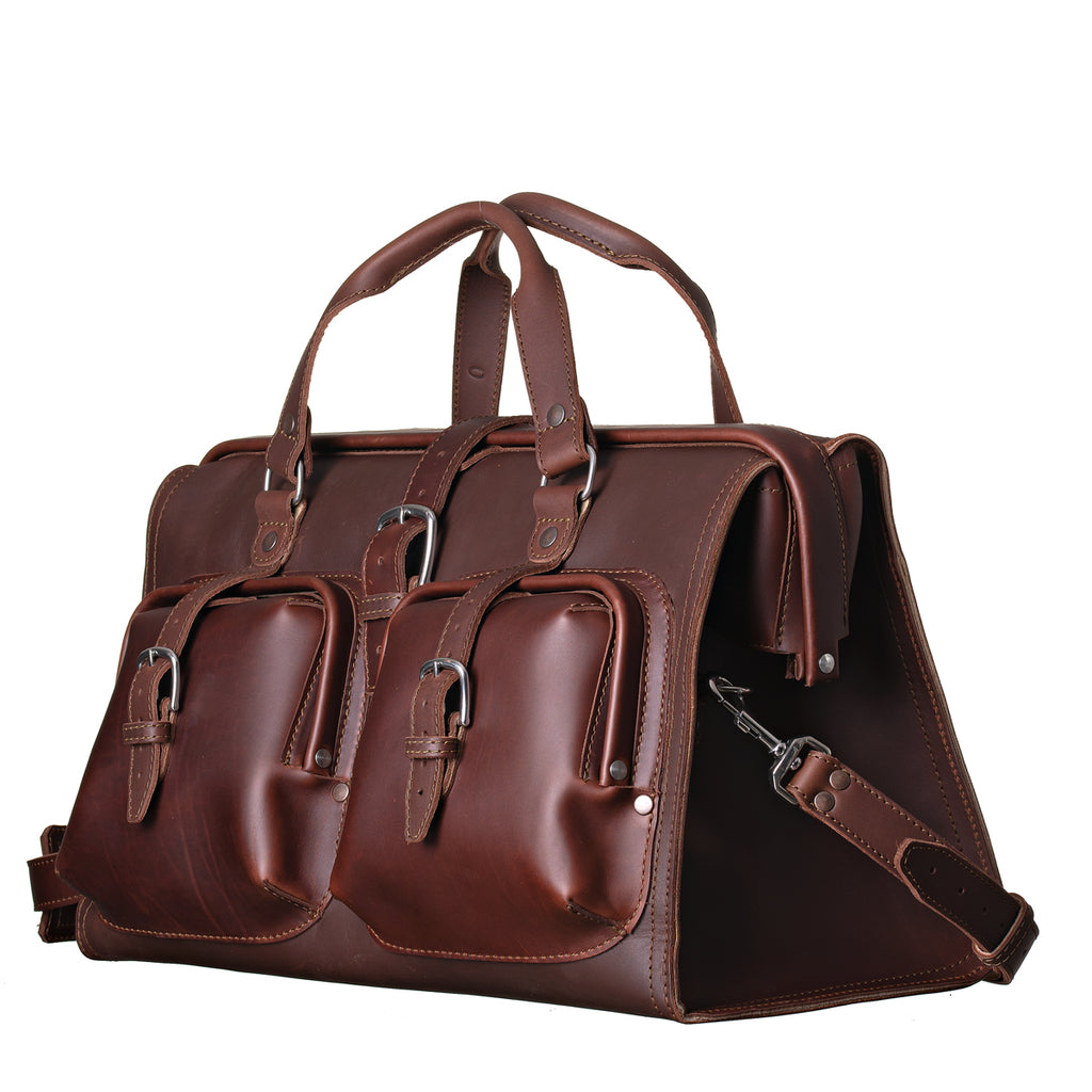 Deep Pocket Leather Duffle Bag in Chestnut, angled front view with two buckled front pockets