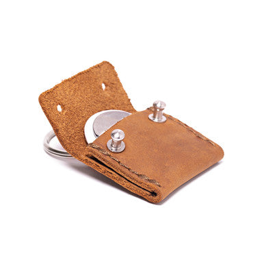 The Pouch Leather AirTag Keychain Case in tan, flap open showing AirTag inside with rivet closures
