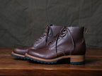 Huntsman Boots in Dark Coffee Brown, pair with lug soles and stacked heels on a wooden table