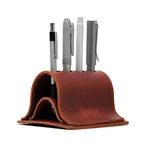 Pen Holder Bell Curve in Chestnut leather, front view holding four pens with embossed Saddleback Leather Co. logo