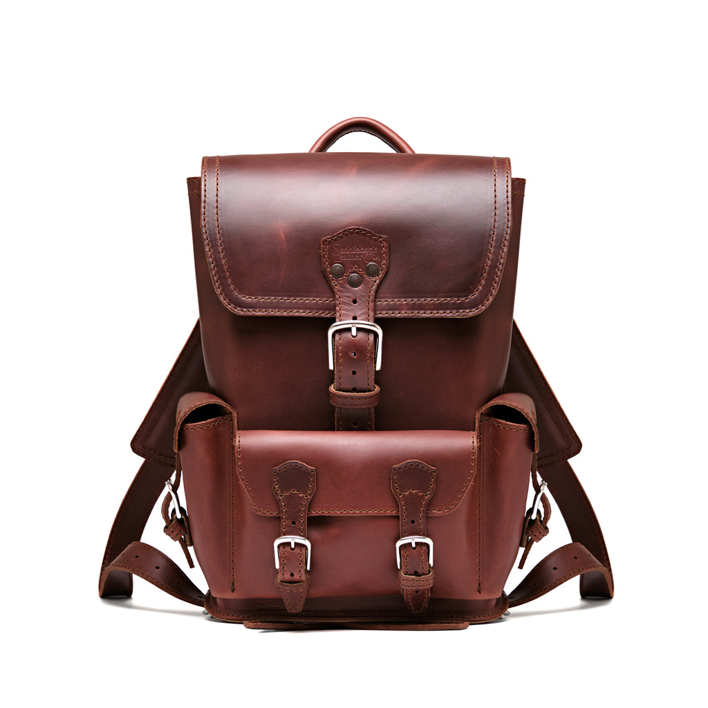 Small Front Pocket Backpack in Chestnut, front view showing the buckled flap, front pocket and shoulder straps