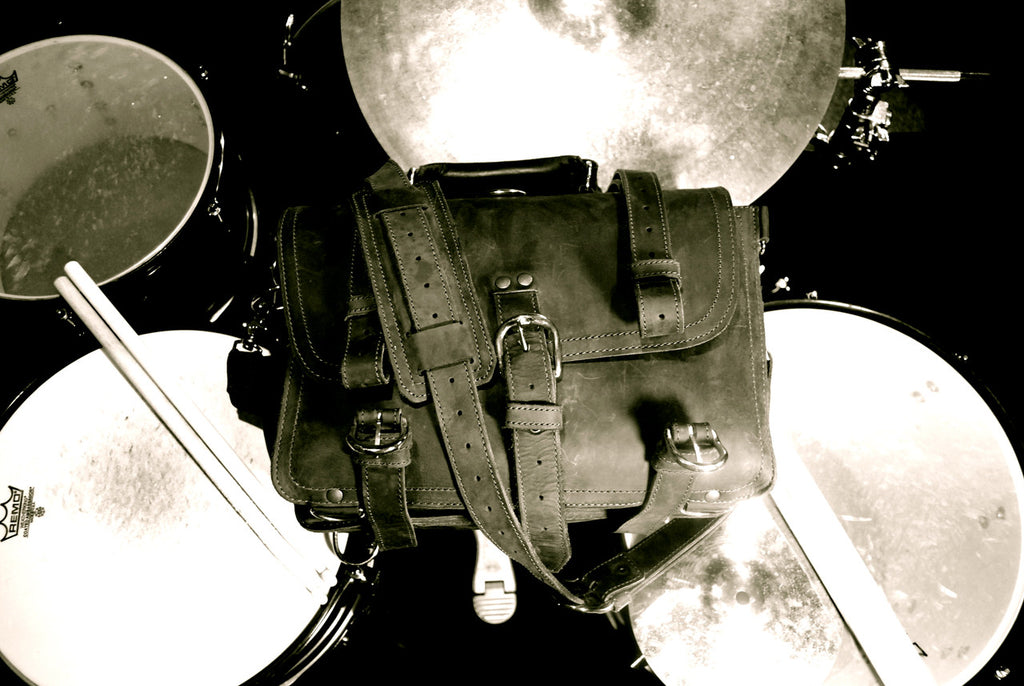 Large Classic Leather Briefcase, black and white top view resting on a drum kit with drumsticks and cymbals
