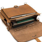 Slim Leather Briefcase in Tobacco, top view with flap open showing a laptop, notebooks and a tablet in the compartments