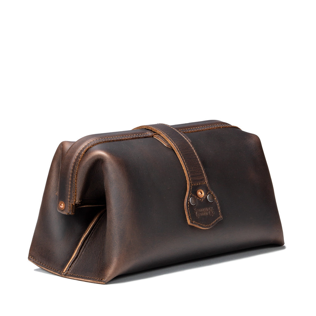 Big Mouth Leather Toiletry Bag in Dark Coffee Brown, angled back view showing riveted strap end