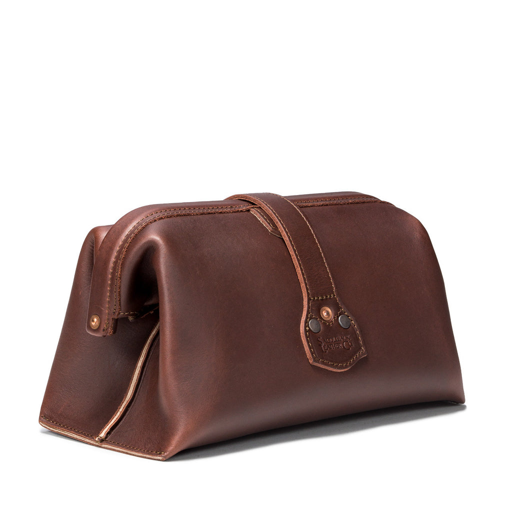 Big Mouth Leather Toiletry Bag in Chestnut, angled back view showing riveted strap end