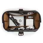 Little Big Mouth Toiletry Bag in Black, top view open holding a hard drive, chargers and coiled cables