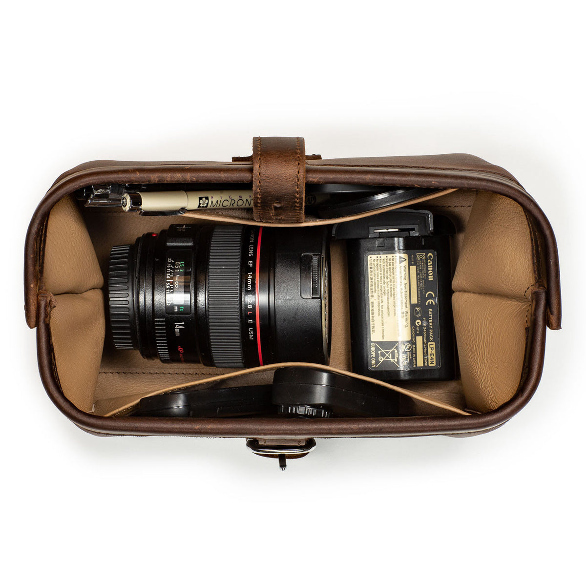 Little Big Mouth Toiletry Bag in Dark Coffee Brown, top view open holding a camera lens, battery and pen
