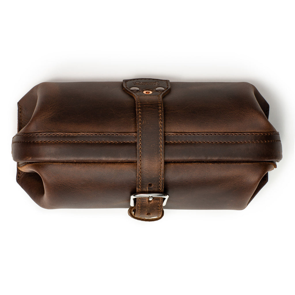 Little Big Mouth Toiletry Bag in Dark Coffee Brown, top view closed with the leather strap buckled over the frame