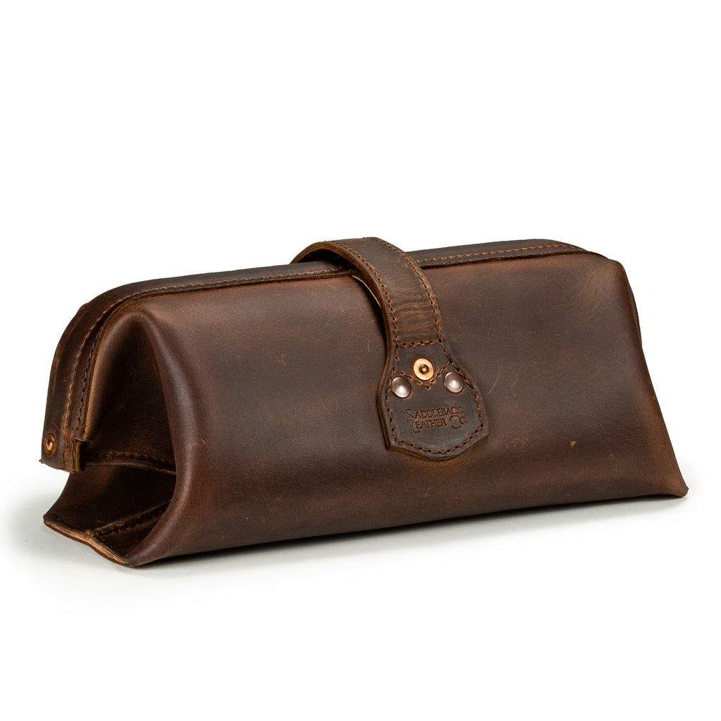 Little Big Mouth Toiletry Bag in Dark Coffee Brown, angled back view with riveted strap tab and embossed logo