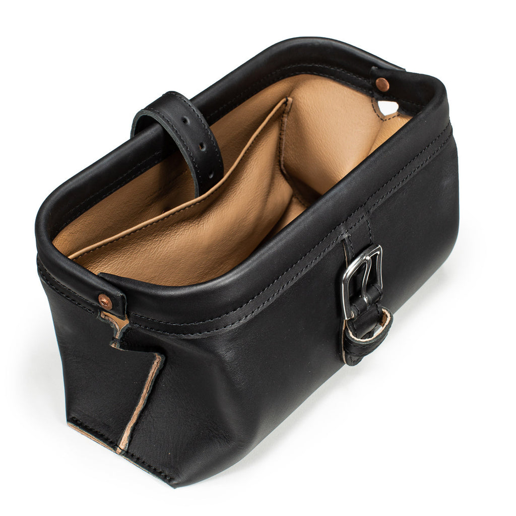 Little Big Mouth Toiletry Bag in Black, angled view with the frame mouth open showing the lined interior