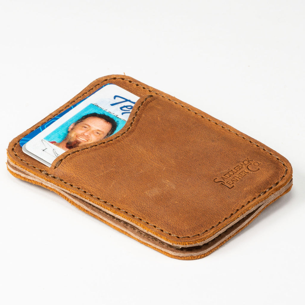 Slim Leather Card Wallet in Tobacco lying flat at an angle with an ID card in the front pocket