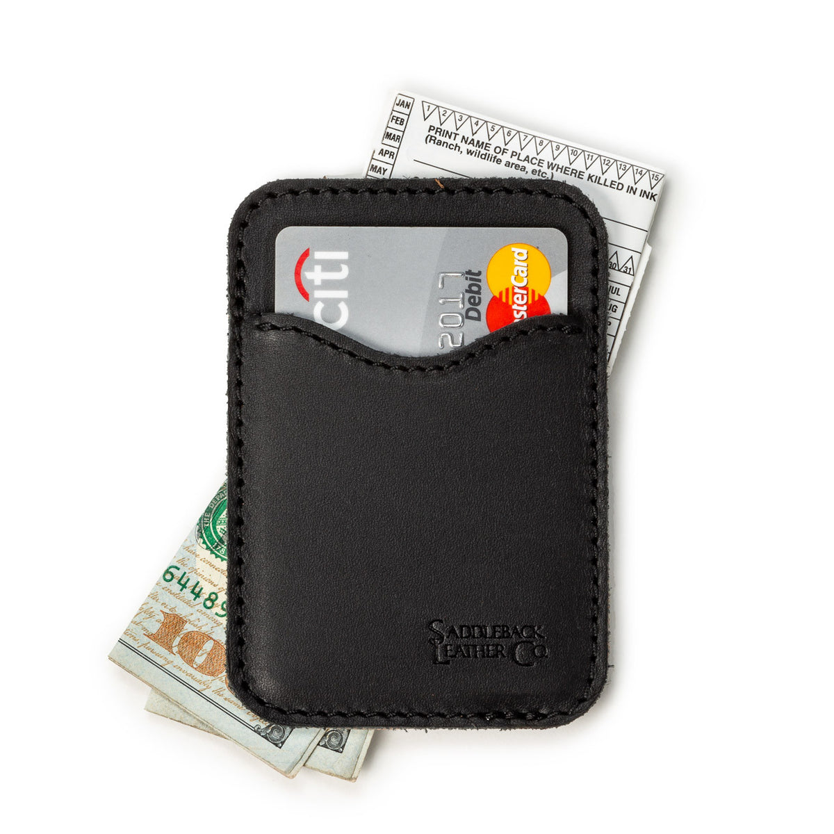 Slim Leather Card Wallet in Black lying flat with a debit card in the front pocket over cash and a receipt