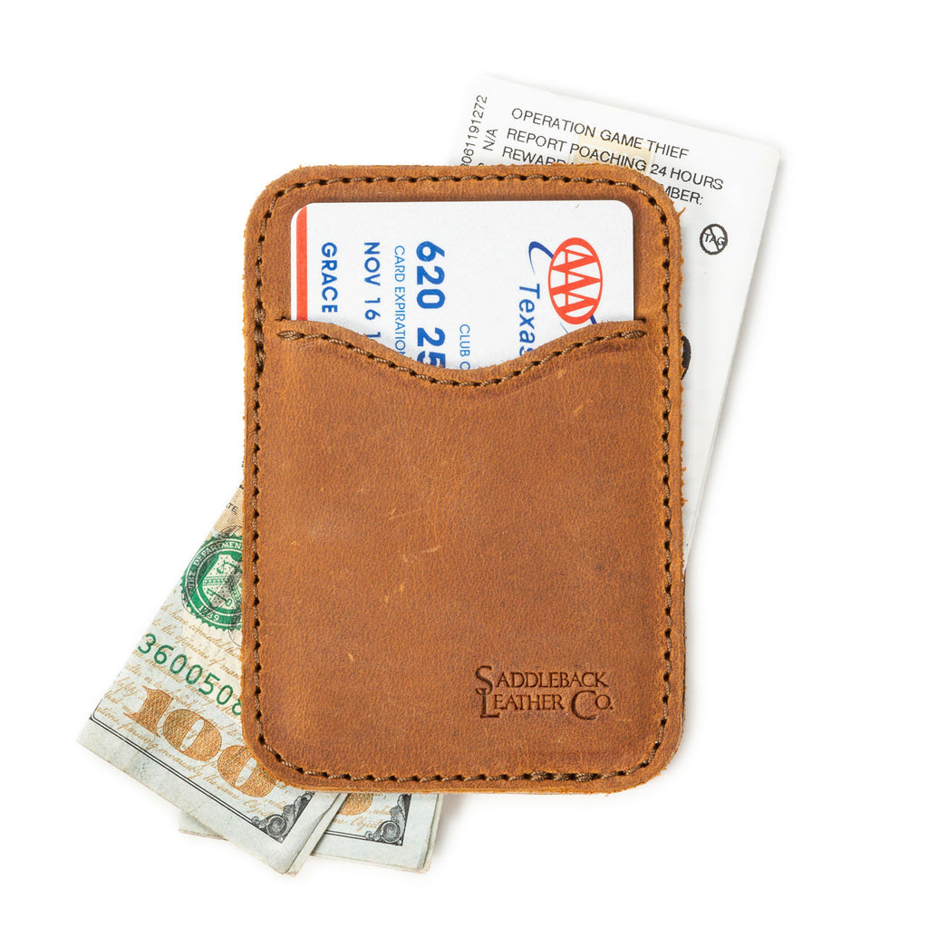 Slim Leather Card Wallet in Tobacco lying flat with a card in the front pocket over cash and a card