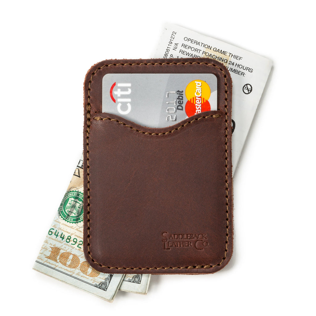 Slim Leather Card Wallet in Chestnut lying flat with a debit card in the front pocket over cash and a card