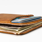 Slim Leather Card Wallet in Tobacco, close-up of the stitched edge with cards and cash packed inside