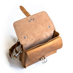Front Pocket Leather Satchel in Tobacco with the flap open, showing the front pocket buckle and shoulder strap clip