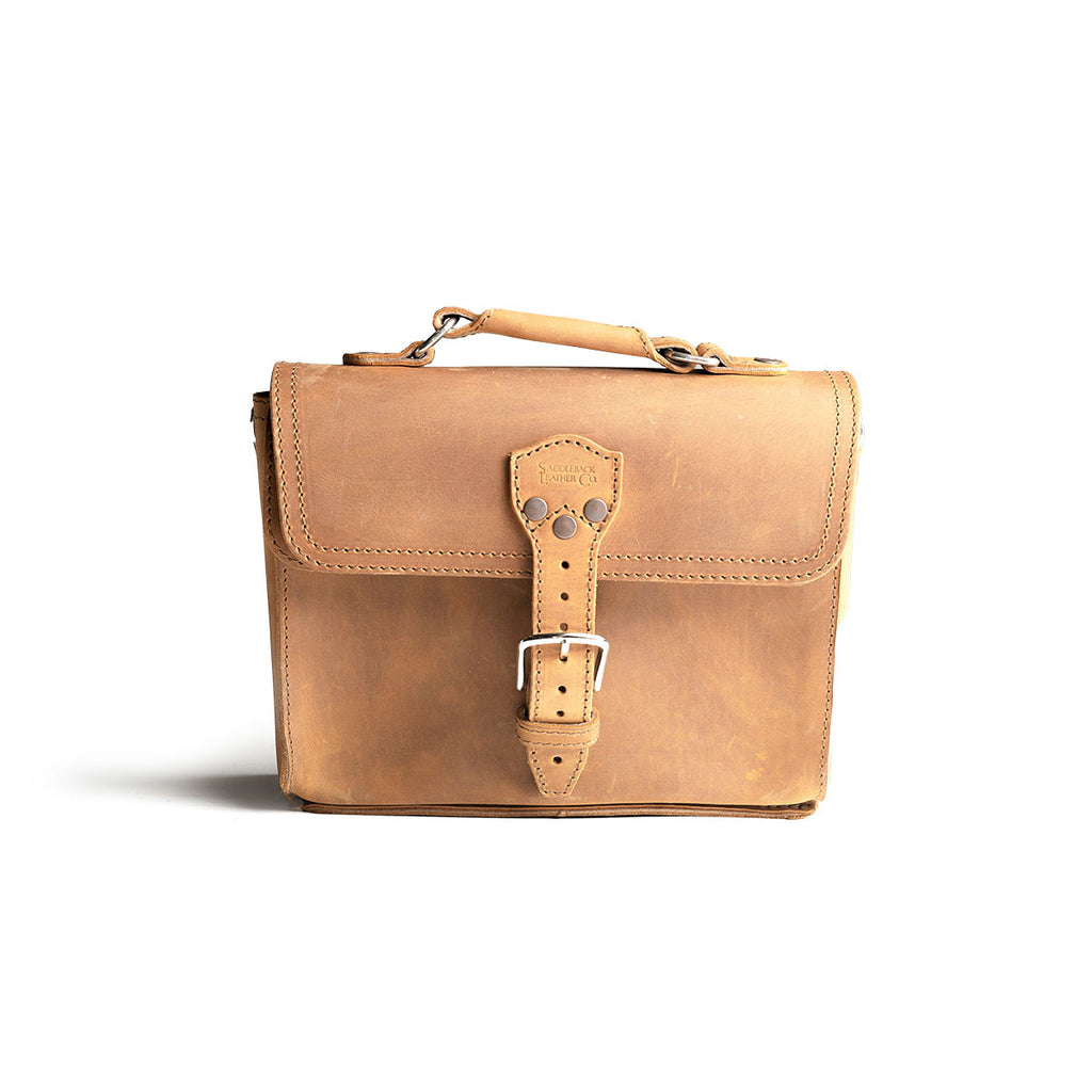 Front Pocket Leather Satchel in Tobacco, straight-on front view with riveted buckle strap and top handle