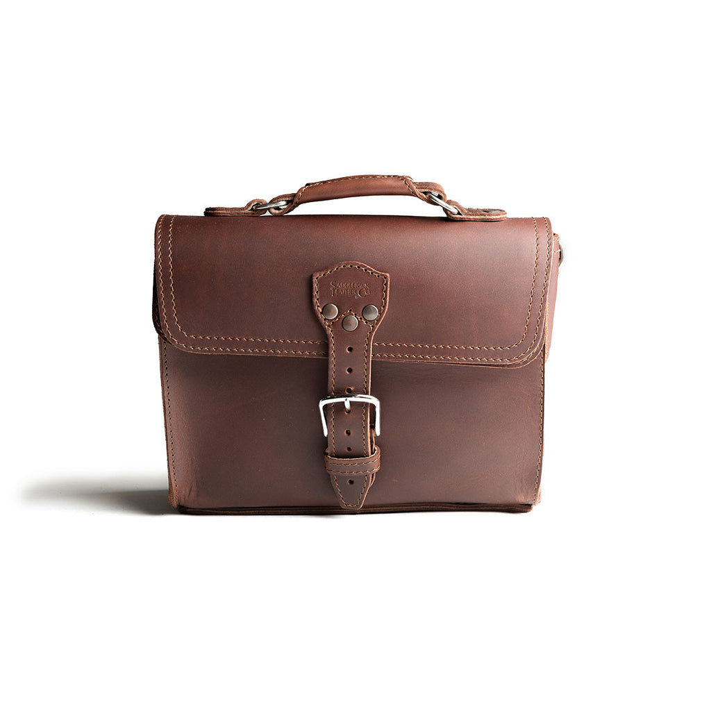 Front Pocket Leather Satchel in Chestnut, straight-on front view with riveted buckle strap and top handle