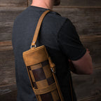 Leather Travel Chess Set in Tobacco, rolled checkerboard case worn over a man's shoulder by its leather strap