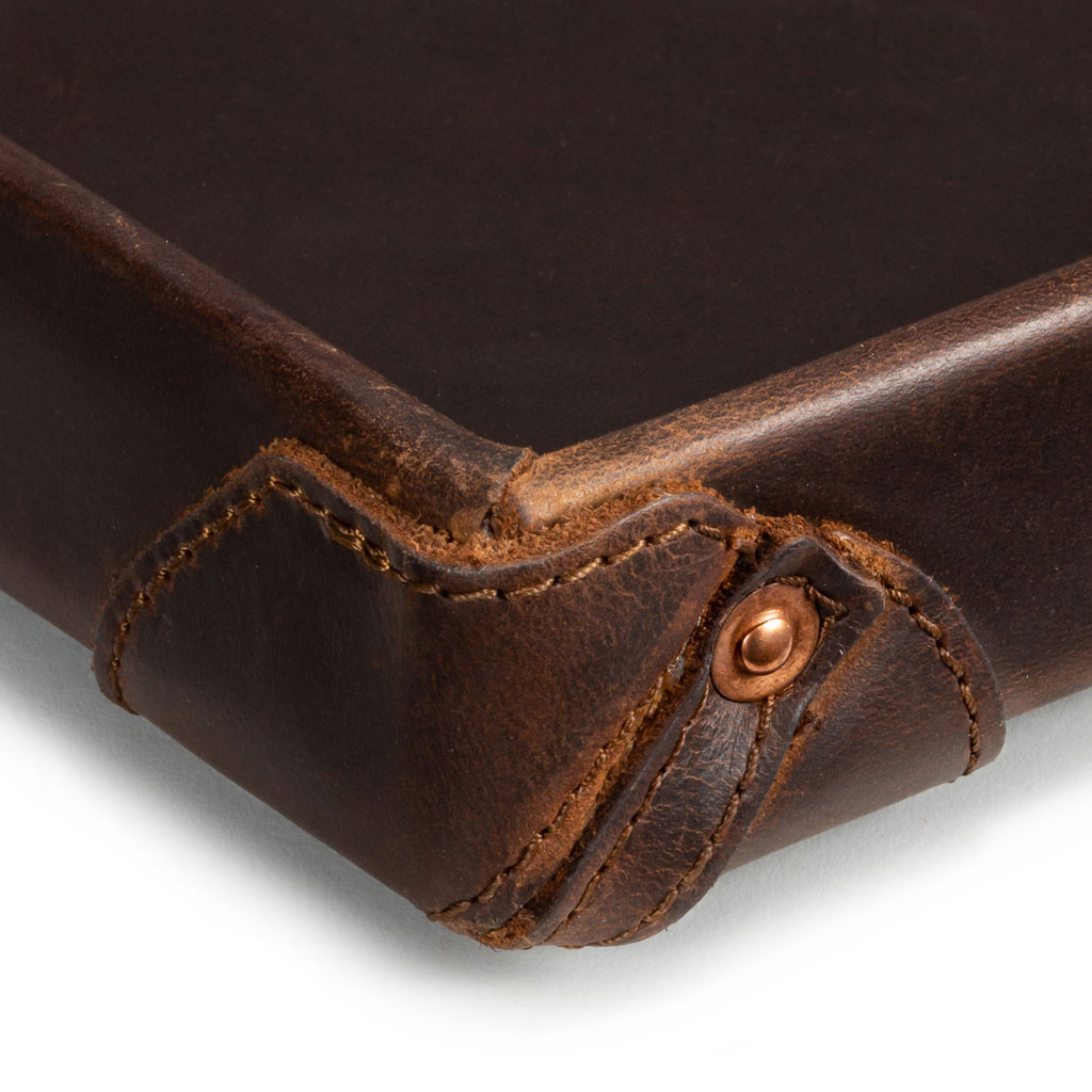 The Leather Grandfather Valet Tray in Dark Coffee Brown, close-up of a stitched corner tab with copper rivet