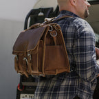 Front Pocket Leather Briefcase in Tobacco worn as a backpack by a man in a plaid flannel shirt