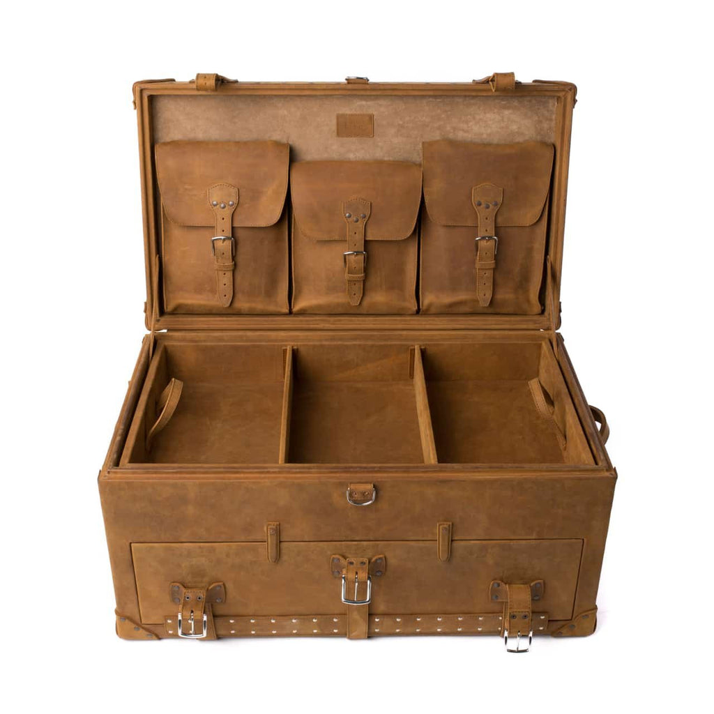 Leather Trunk in Tobacco, open with three buckled lid pockets above a divided top tray and strapped front