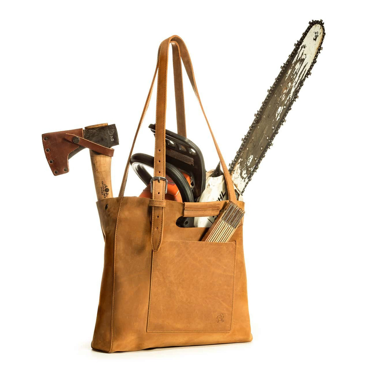 Everyday Leather Tote in Tobacco packed with an axe, chainsaw, ear protection and folding ruler