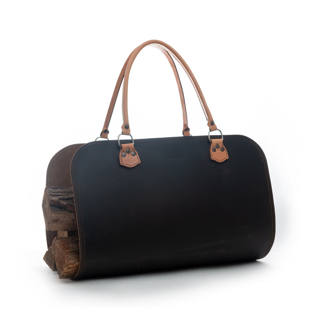 Leather Log Carrier in Dark Coffee Brown with tan carry handles, holding firewood, side view