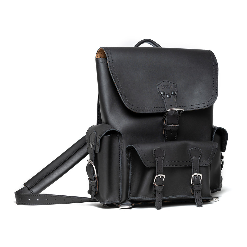 Front Pocket Leather Backpack in Black, angled view with buckled flap, front pockets and strap