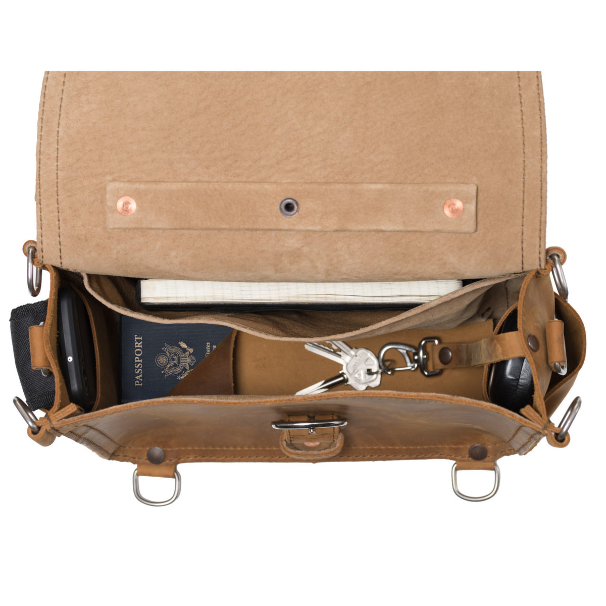 Photographer's Satchel in Tobacco, top view open with a passport, keys and notebook inside