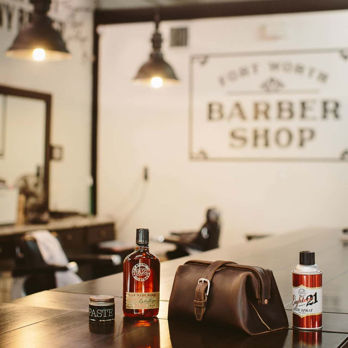 Big Mouth Leather Toiletry Bag in Dark Coffee Brown on a barber shop counter beside grooming bottles