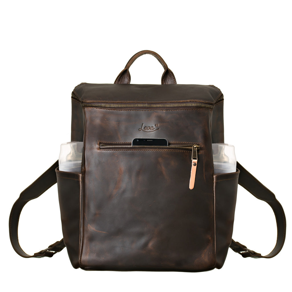 All in One Leather Backpack in Dark Coffee Brown, front view with a phone in front pocket and items in side pockets