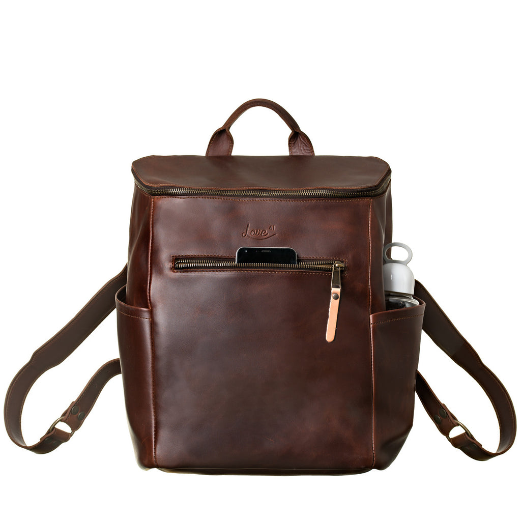 All in One Leather Backpack in Chestnut, front view with a phone in the front pocket and bottle in the side