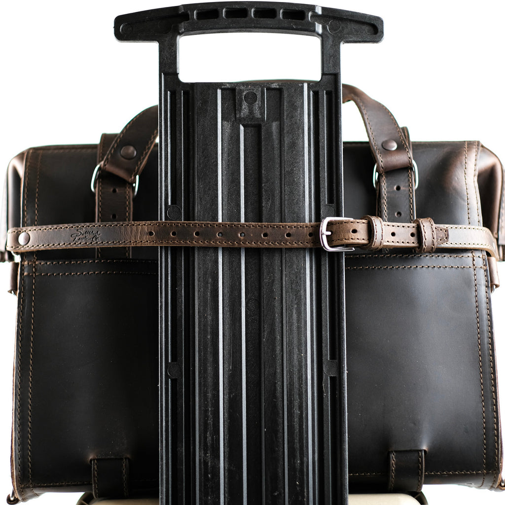 Leather Luggage Strap in Dark Coffee Brown buckled around a briefcase to secure it to a rolling suitcase handle