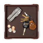 The Leather Grandfather Valet Tray in Chestnut, top-down view holding a multi-tool, keys, key fob and coins