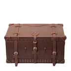 Leather Trunk in Chestnut, closed front view with three buckled straps, studded trim and corner guards